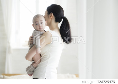 赤ちゃんを抱く母親 128725473