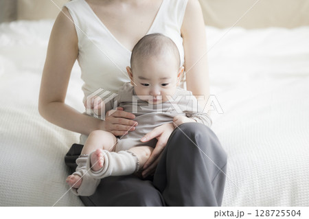 赤ちゃんを抱く母親 128725504