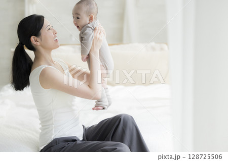 赤ちゃんを抱く母親 128725506