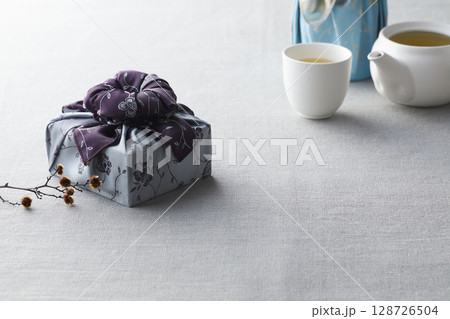 Elegant Korean table setting with traditional Korean bojagi gift wrapping for Chuseok, ceramic vase and fabric, tree branches. Elegant Korean table setting with traditional Korean bojagi gift wrapping for Chuseok, ceramic vase and fabric, tree branches. 128726504