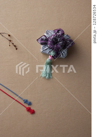 Elegant Korean table setting with traditional Korean bojagi gift wrapping for Chuseok, ceramic vase and fabric, tree branches. 128726534