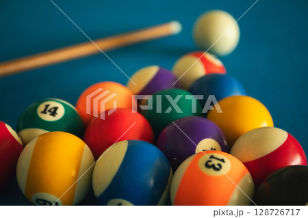 Billiard balls are arranged for a game on a blue felt table 128726717