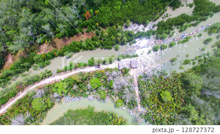 Aerial View of Riverside Dock with Wooden Boats in Tropical Mangrove Area 128727372
