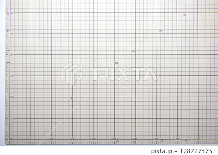 gray cutting mat board background with line and scale measure guide pattern for object art design, tool equipment of diy craft work 128727375