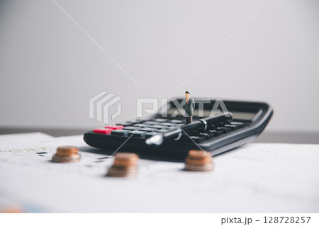 Financial calculate accountant blur background close up on calculator with graph chart banner bank office desk. Finance Concept tax banking money expense accounting budget businessman use calculator. Financial calculate accountant blur background close up on calculator with graph chart banner bank office desk. Finance Concept tax banking money expense accounting budget businessman use calculator. 128728257