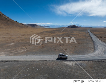 Aerial view of offroad car running on high elevation lakeside Aerial view of offroad car running on high elevation lakeside 128728310