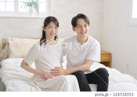 夫婦のポートレート 妊娠している妻のお腹を触る夫 夫婦のポートレート 妊娠している妻のお腹を触る夫 128728353