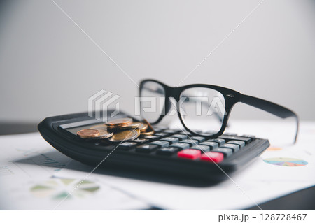 Financial calculate accountant blur background close up on calculator with graph chart banner bank office desk. Finance Concept tax banking money expense accounting budget businessman use calculator. 128728467