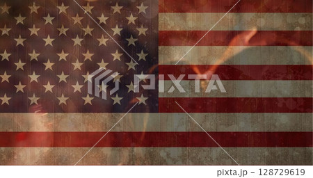 Displaying worn American flag burning with stylized flames on digital poster, with smoke overlay Displaying worn American flag burning with stylized flames on digital poster, with smoke overlay 128729619