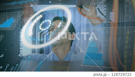 Interacting IT tech operating holographic interface inside data center, with racks, network cables Interacting IT tech operating holographic interface inside data center, with racks, network cables 128729722