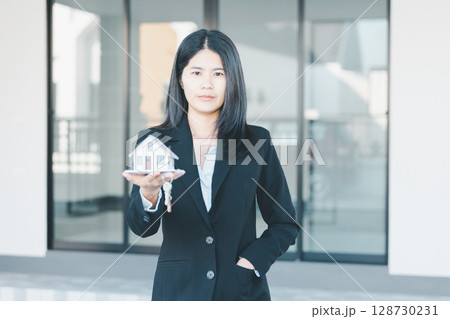 Woman hand hold key buy home model business concept involves sell financial management investment bank loan ownership income economy finance investments purchasing apartment blur background estate 128730231