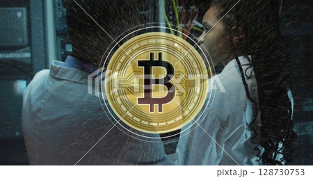 Image of bitcoin sing over african american couple using laptop in server room Image of bitcoin sing over african american couple using laptop in server room 128730753