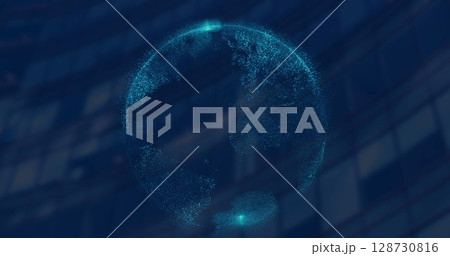 Image of spinning globe against tall building in background 128730816