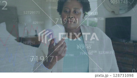 Multiple changing numbers over african american senior woman measuring her temperature at home Multiple changing numbers over african american senior woman measuring her temperature at home 128731098