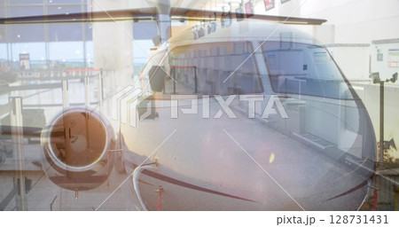 Displaying private jet nose over airport gate area, with business casual woman rolling suitcase Displaying private jet nose over airport gate area, with business casual woman rolling suitcase 128731431