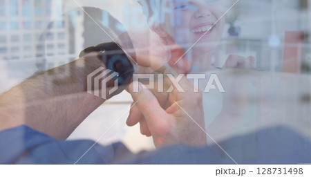 Image of man's hand using smartwatch over diverse children 128731498