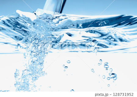 青の背景に水槽に注ぐ水。 青の背景に水槽に注ぐ水。 128731952