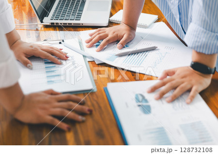 People meeting using laptop computer, calculator, stock market chart paper for analysis plans to improve quality. Team working on project. Analysis business brainstorming corporate smart Concept. 128732108