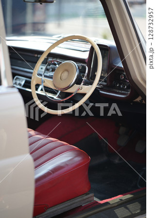 Vintage Classic car steering wheel, with chrome and leather textures in sharp detail, showcases the quality and precision of automotive craftsmanship under natural light. 128732957