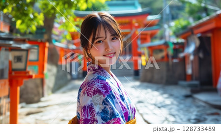 神社の境内にいる浴衣姿の若い女性 128733489