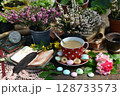 Still life with cup of tea, open diary book and flowers of veresk and rose on the table in the garden. Romantic, vintage home and greeting card concept Still life with cup of tea, open diary book and flowers of veresk and rose on the table in the garden. Romantic, vintage home and greeting card concept 128733573