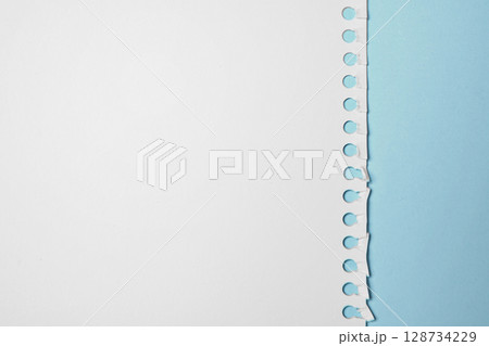 Notebook sheet. Torn page from a notebook on a blue background. Copy space 128734229