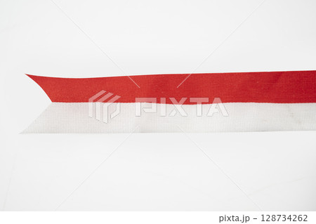 The striped red and white ribbon of the Indonesian flag on a white background. Concept of Indonesian Independence Day or Kemerdekaan 128734262