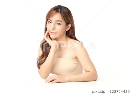 A beautiful young Asian woman with clean, fresh skin against a white background. Skincare, facial treatment, cosmetology, beauty, and spa. An elegant portrait of an Asian woman. 128734429