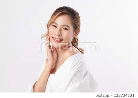 A beautiful young Asian woman with clean, fresh skin against a white background. Skincare, facial treatment, cosmetology, beauty, and spa. An elegant portrait of an Asian woman. A beautiful young Asian woman with clean, fresh skin against a white background. Skincare, facial treatment, cosmetology, beauty, and spa. An elegant portrait of an Asian woman. 128734531