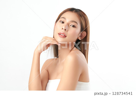 A beautiful young Asian woman with clean, fresh skin against a white background. Skincare, facial treatment, cosmetology, beauty, and spa. An elegant portrait of an Asian woman. A beautiful young Asian woman with clean, fresh skin against a white background. Skincare, facial treatment, cosmetology, beauty, and spa. An elegant portrait of an Asian woman. 128734541