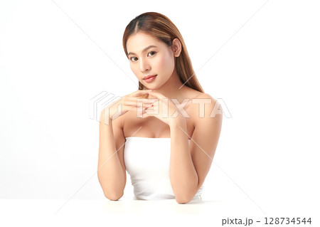 A beautiful young Asian woman with clean, fresh skin against a white background. Skincare, facial treatment, cosmetology, beauty, and spa. An elegant portrait of an Asian woman. 128734544