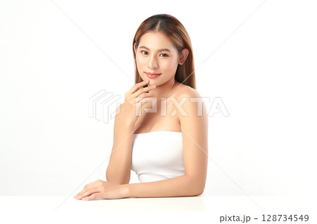 A beautiful young Asian woman with clean, fresh skin against a white background. Skincare, facial treatment, cosmetology, beauty, and spa. An elegant portrait of an Asian woman. A beautiful young Asian woman with clean, fresh skin against a white background. Skincare, facial treatment, cosmetology, beauty, and spa. An elegant portrait of an Asian woman. 128734549