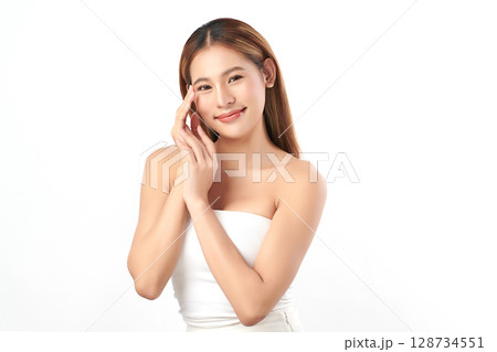 A beautiful young Asian woman with clean, fresh skin against a white background. Skincare, facial treatment, cosmetology, beauty, and spa. An elegant portrait of an Asian woman. 128734551
