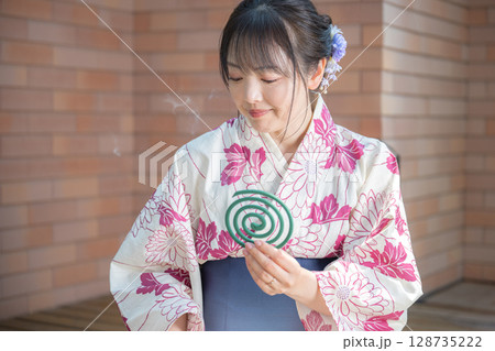 蚊取り線香の煙と浴衣女性 128735222