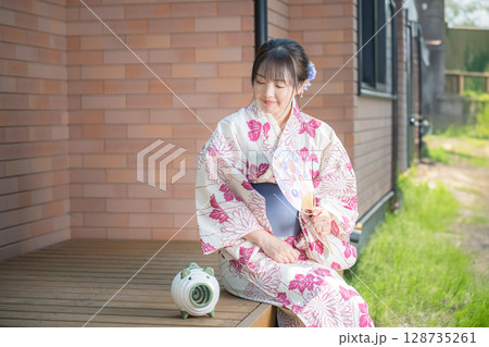 笑顔で涼む浴衣女性 128735261