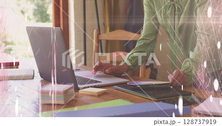 Image of screens of network of connections against mid section of woman using laptop 128737919