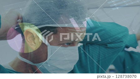 Image of data processing over caucasian male surgon wearing face mask 128738070