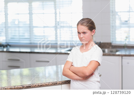 Woman leaning against granite countertop in modern kitchen, frowning with crossed arms, copy space Woman leaning against granite countertop in modern kitchen, frowning with crossed arms, copy space 128739120