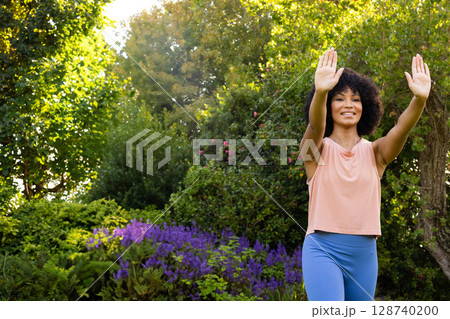 Woman practicing tai chi in lush garden setting, with focus on balance and wellness, copy space Woman practicing tai chi in lush garden setting, with focus on balance and wellness, copy space 128740200