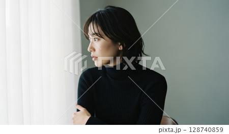 窓辺の黒タートルネック女性のポートレート写真 128740859