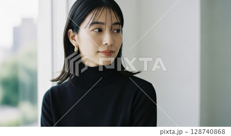 窓辺の黒タートルネック女性のポートレート写真 128740868