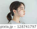 白い背景の前で横を向くポニーテールの日本人女性のナチュラルポートレート 128741797