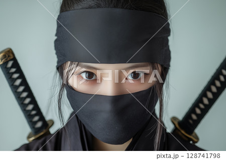 二本の刀を背負い黒装束に身を包んだ若い日本人女性のクローズアップ忍者ポートレート 128741798