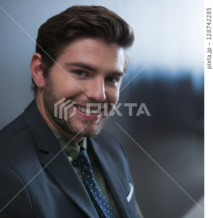 Male business professional smiling at camera in office, wearing olive-green shirt and polka-dot tie 128742285