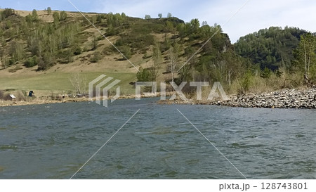 Picturesque mountain river landscape with lush vegetation and clear blue sky above scenery 128743801