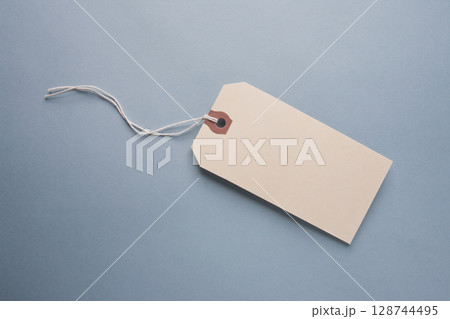 Studio shot of blank hang tag on blue background Studio shot of blank hang tag on blue background 128744495