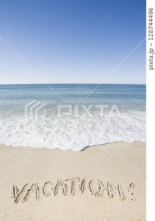Vacation message written in beach sand Vacation message written in beach sand 128744496