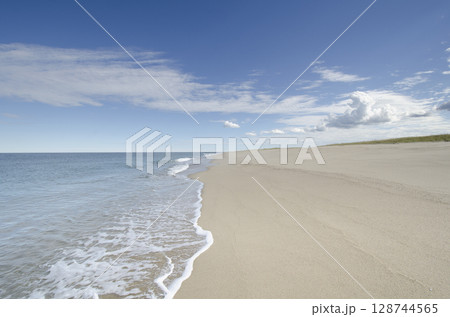 Ocean waves on empty sandy beach Ocean waves on empty sandy beach 128744565