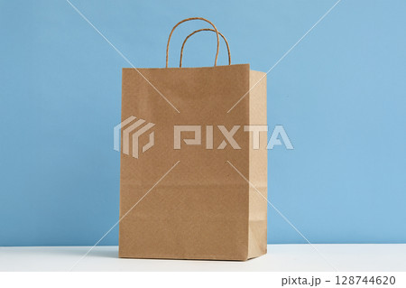 Studio shot of paper shopping bag on blue background 128744620