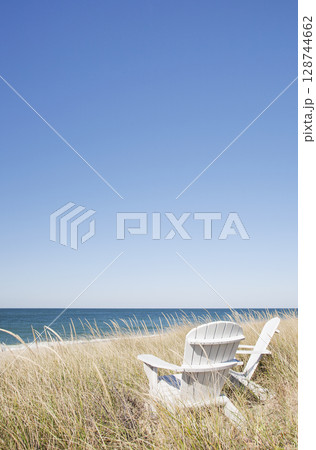Adirondack chairs facing beach and ocean Adirondack chairs facing beach and ocean 128744662